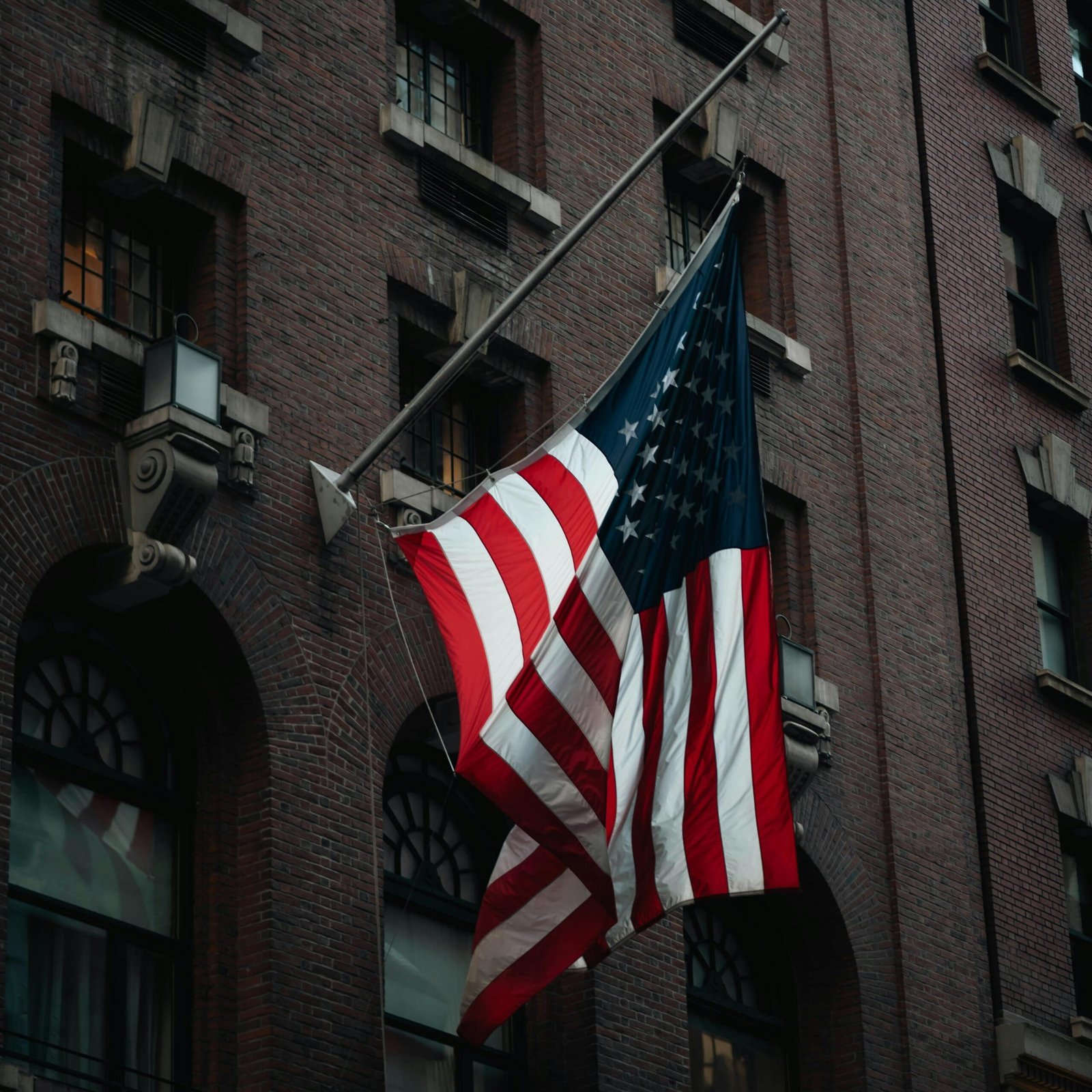 United States flag hanging on a historic building in New York City, NY.